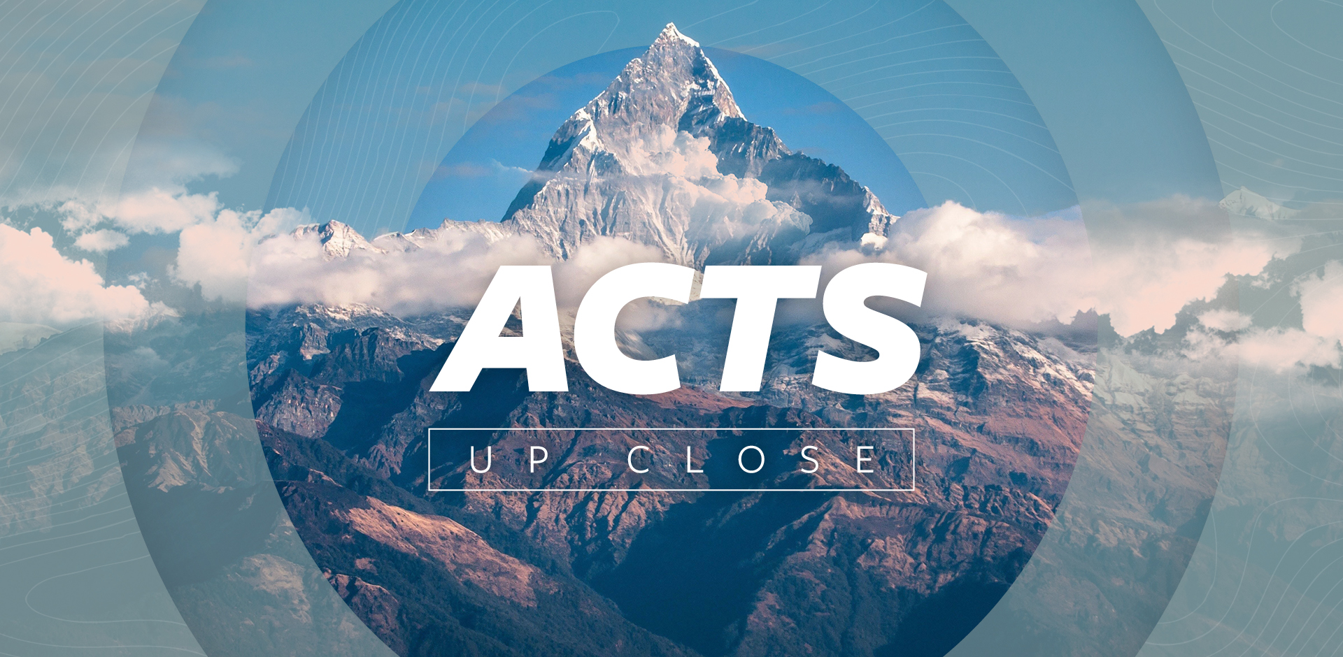 Acts up close against a background of a rugged mountain reaching above the clouds